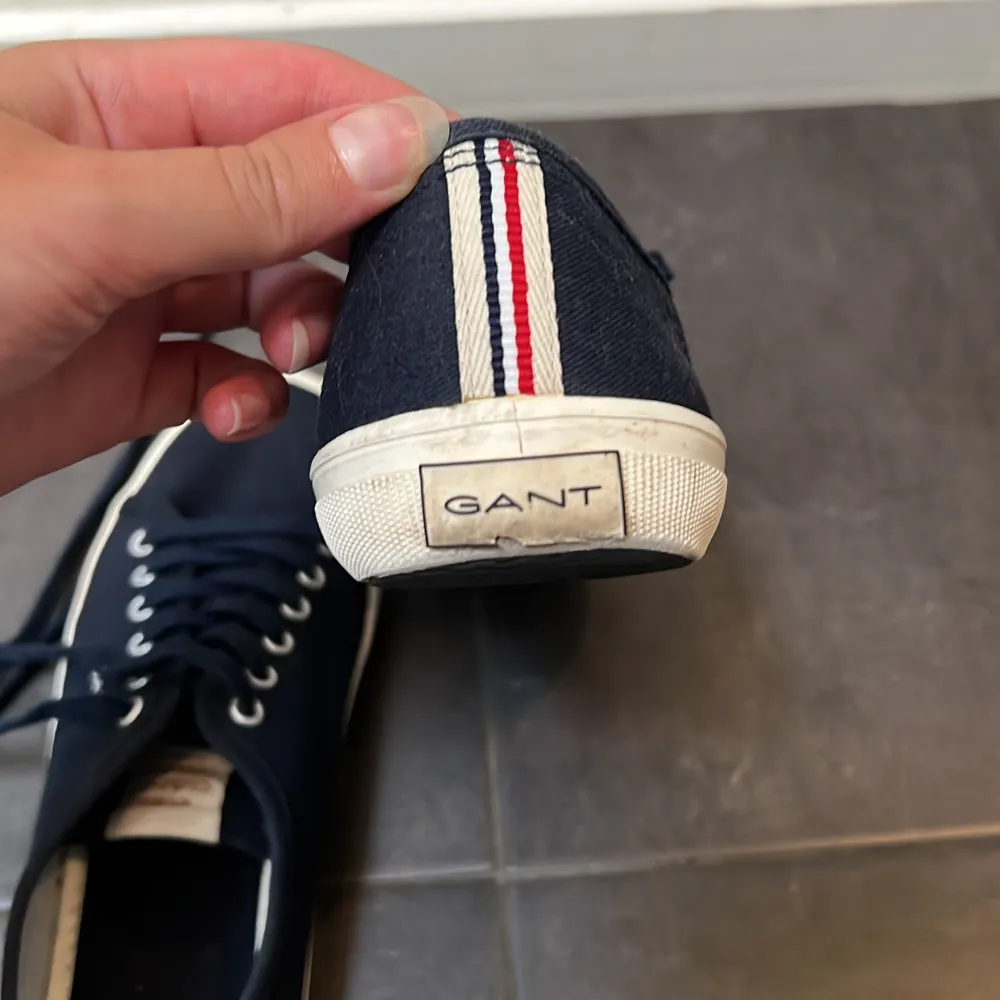 Säljer ett par fina mörkblå sneakers från Gant. De är inte mycket använda men gant märket på hälen är lite skadat (se bild 3).. Skor.
