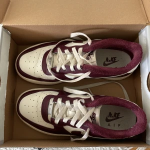 Nike air force 1 LV8  - Sjukt snygga Nike air force i vinröd, använt men fortfarande väldigt bra skick! 23,5 cm i storleken 37,5 