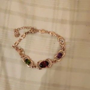 Guldarmband med stenar - Guldarmband med färgade stenar.  Justerbar och skön att ha på sig.