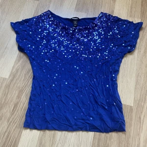 Glittrig topp - En blå glittrig topp från H&m i storlek xs