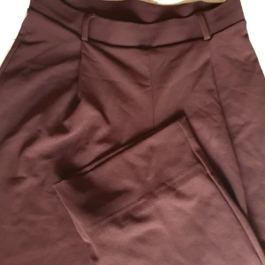 bruna kostymbyxor  - flowy kostymbyxor med resår så de sitter bekvämt. Har tagit upp byxbenen lite men det går att ta bort och få utterligar 10cm i längd. Använd en gång.