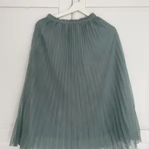 En turkos plisserad kjol från hm med små små märken som knappt syns i verkligheten (se bild)