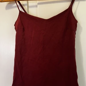 Rött linne  - Ett rött linne i storlek M, sömmen har släppt lite vid ärmen men går nog att laga, använt skick. Kan skickas med frakt, Swish betalning. 