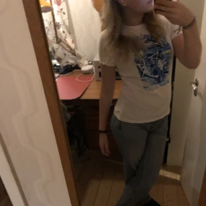 Vit t shirt med blått inslag - Hej! Jag säljer min vita t shirt med lite blått inslag i mitten. Skriv för fler bilder!