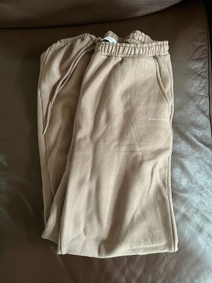 Nicki studios mjukis - Beiga mjukis med mudd längst ner från nicki studios, byxorna är små i storleken därav storleken för en oversize fit i benen. Ursnygga med används dessvärre ej. 