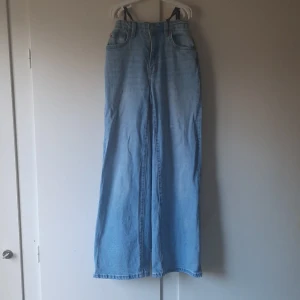 Ljusblåa jeans - Lite gröna på fickorna men deg syns inte jättemycket.