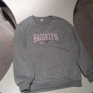 En fin grå hoodie med text Brooklyn 