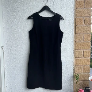 Superfin svart klänning i mockaliknande tyg - Superfin svart klänning i mockaliknande tyg i jättefint skick. Perfekt till fest. Storlek 40