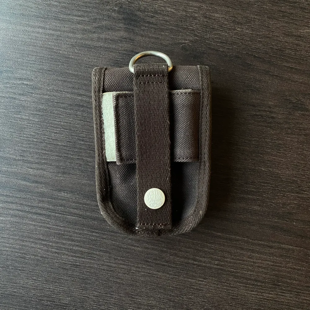 En liten brun pouch/coin purse från japanska märket Porter Yoshida  Väskan har brun färg med insida och resorband i cream färg.   Går att fästa till remmen i andra väskor som accessoar.  Som i nyskick!. Väskor.