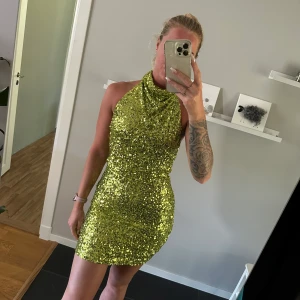 Paljettklänning  - Paljettklänning från Gina med öppen rygg. Använd 1 gång.  (båda knapparna vid halsen går att stänga jag orkade bara inte för fotot). 