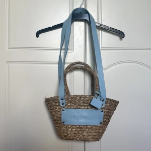 Väska Núnoo - Fin strandväska från Núnoo med blåa band. Väldigt gott skick, aldrig använd. 