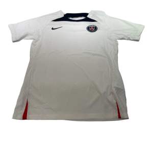  En PSG-tröja i storlek M som är vit. Den är perfekt passande och av hög kvalitet. Dess andningsförmåga gör den idealisk för både matcher och träning.