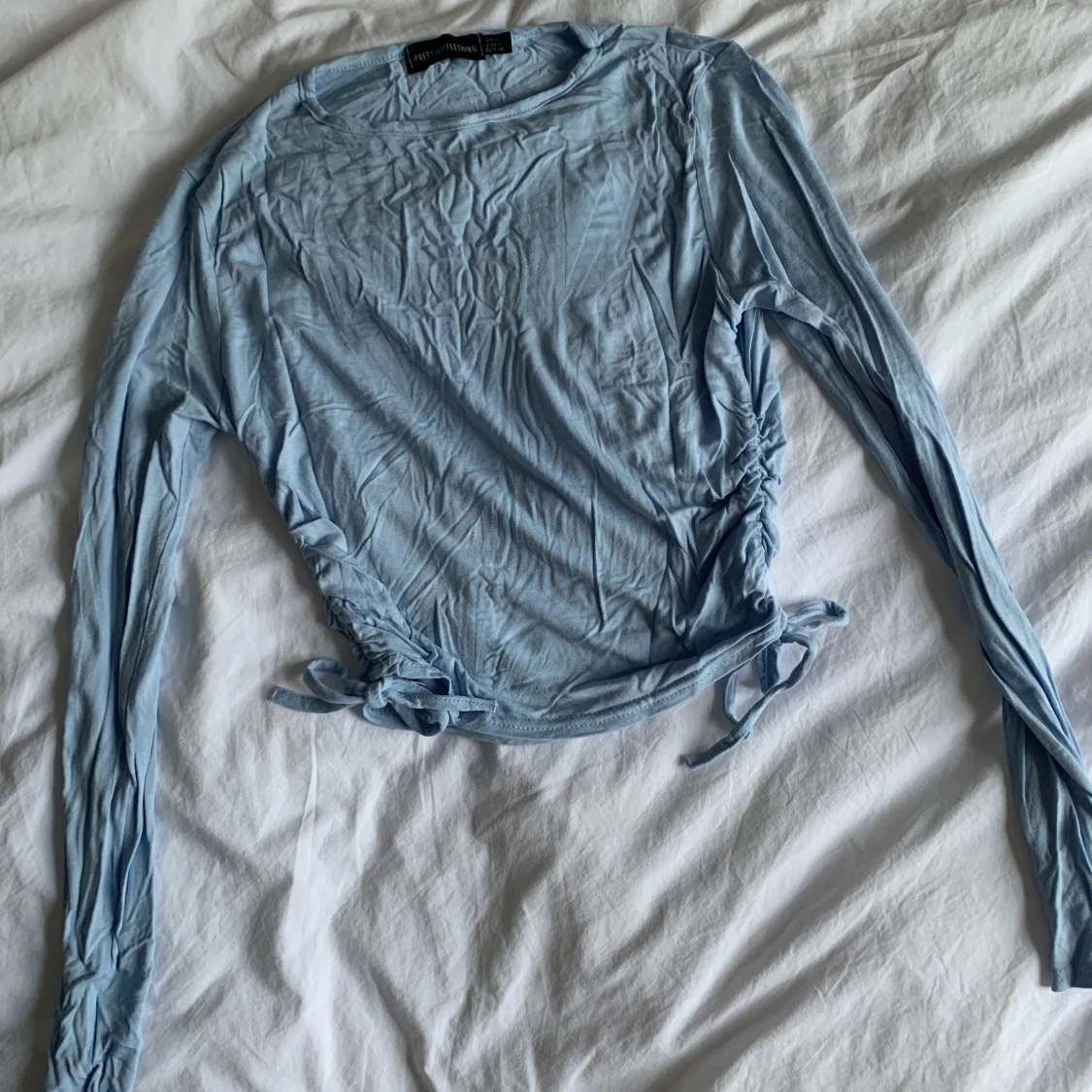 Blå topp med knyt i sidorna