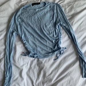 Blå topp med knyt i sidorna  - Väldigt fin tröja som bilden inte ger rättvisa