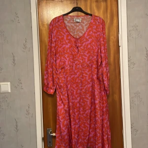 Klänning -  Rosa viskos klänning med mönster i rött  100% viskos 