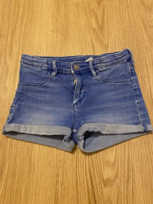 Jeansshorts  - Blåa jeansshorts med anpassningsbar midja i storlek 146