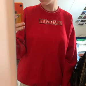 Röd tjocktröja - Väldigt mysig Team Sportia tröja som är köpt på Myrorna, använd ca 5 ggr av mig men säljer den nu då den är förstor. Den har några svarta prickar på högra axeln som kan gå bort i tvätten om man verkligen försöker men lovar inte💘(de syns ej vid användning)