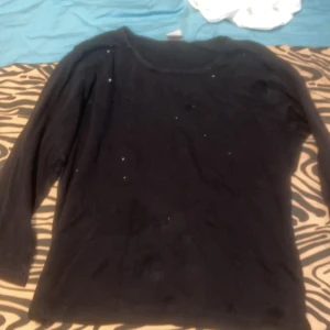 Långärmad - Svart och glittrande långärmad tröja. Jätteskön och inte så tjock i tyget. Passar faktiskt bra till M också