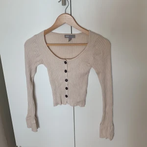 Beige långärmad topp/ kofta - Långärmad beige topp/ kofta. Knapparna går att öppna upp om så vill. Blivit för liten för mig och måste tyvärr därför sälja vidare!