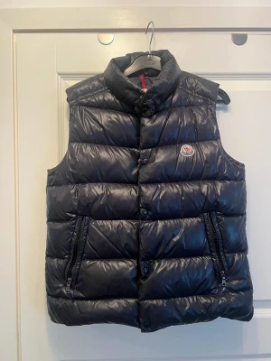 Moncler väst  - Moncler väst, storlek 14yr, 164cm. Den är i bra skick, kvitto saknas men qr koden funkar och den är äkta. Den är mörkblå