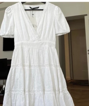 Zara klänning vit  - Säljer denna populära slutsålda klänning från zara 💗aldrig använd ! Klänningen har många fina detaljer och broderi💗lappen fins kvar 💗