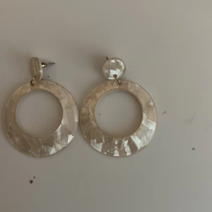 Vita/beiga örhängen - Fina beiga/vita örhängen. Ej nickel fria. Dom är oanvända, bara en gång på bilden. Inte så tunga.