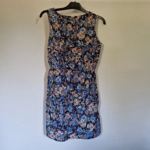 Sommarklänning blommig - Miiten av låren lång. Aldrig använd.