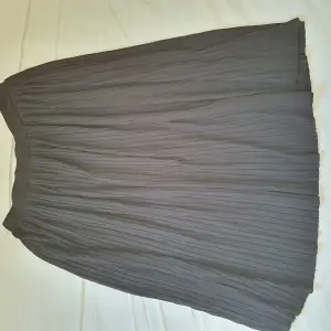 plisserad (veckad) knälång kjol svart från Åhléns