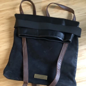 Stylish black backpack - Original leather and suede bag with brown straps. Two inner pockets. Made in Portugal. This backpack fits up to 13,3'' laptop. Dimensions are 35x33 cm