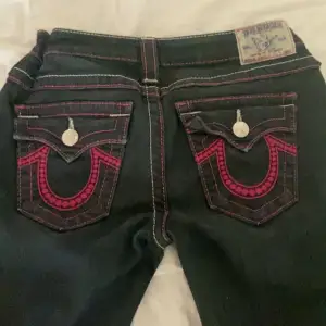 Svart/blåa true religion jeans med rosa detaljer säljer då de inte kommer till användning 