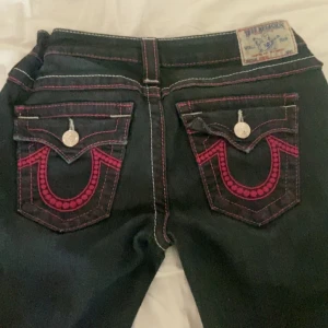 True religion jeans - Svart/blåa true religion jeans med rosa detaljer säljer då de inte kommer till användning 