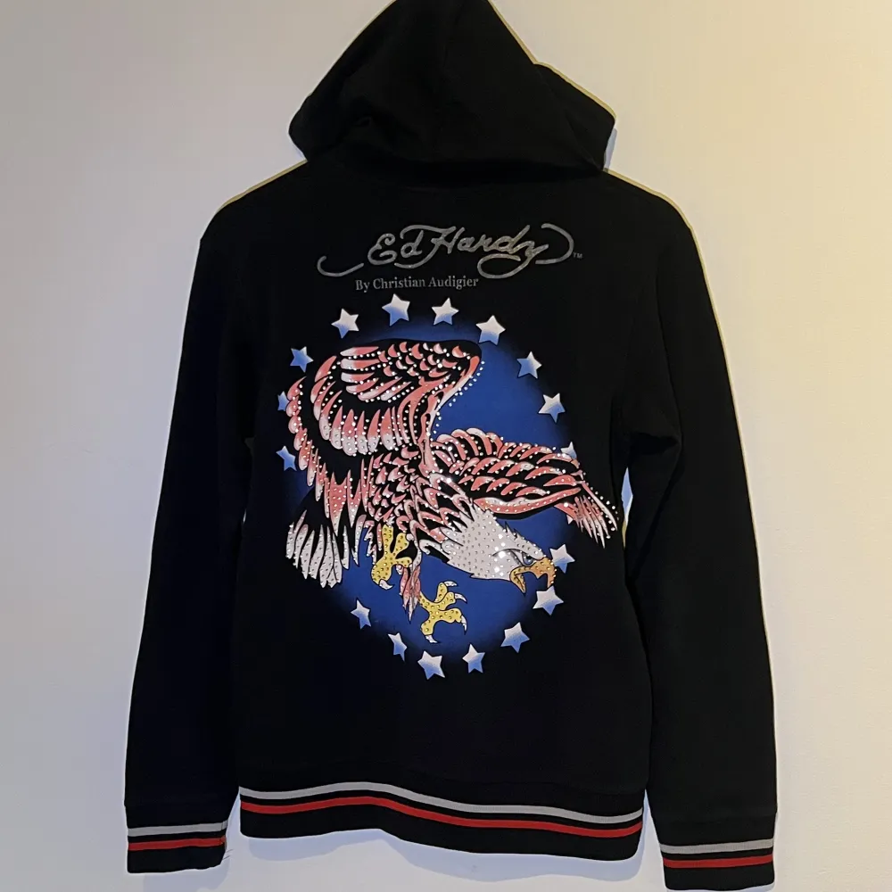 Ed Hardy hoodie köpt second hand. Det står XL men jag skulle säga att det är en S/M då den sitter tight på mig som är i den storleken. Den är ganska tunn och stretchig i materialet, skickar gärna fler bilder vid behov! . Hoodies.