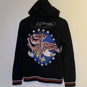 Ed Hardy hoodie - Ed Hardy hoodie köpt second hand. Det står XL men jag skulle säga att det är en S/M då den sitter tight på mig som är i den storleken. Den är ganska tunn och stretchig i materialet, skickar gärna fler bilder vid behov! 