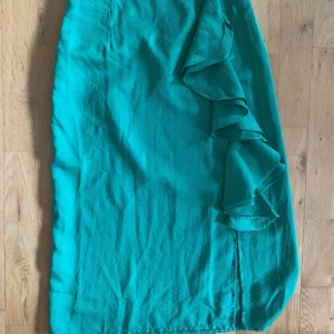 Silkeskjol - Superfin kjol i en härlig grön färg.  Fin volang och slits på sidan. Inte använd så ofta och har inga fläckar eller märken. Skriv privat för fler bilder.