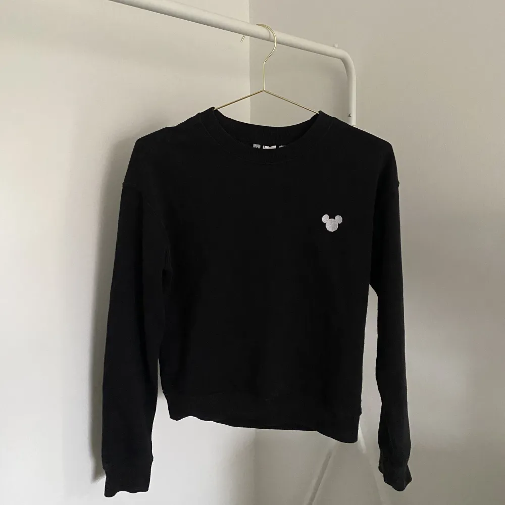 En svart sweatshirt med Mussepigg i vänstra hörnet från H&M. Storlek XS. . Tröjor & Koftor.