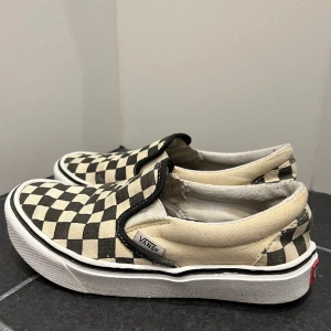 Vans Slip-On - Vans Slip-On i svart- och off whiterutigt. Bra skick! Storlek 34,5. 150:- ex frakt. 