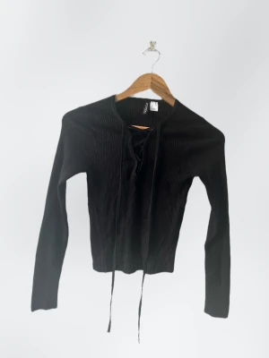 Topp - Långärmad topp från H&M. Använd ett par gånger men i bra skick. Rätt långa snören på den som man antigen kan klippa av eller knyta, alternativ ta bort helt