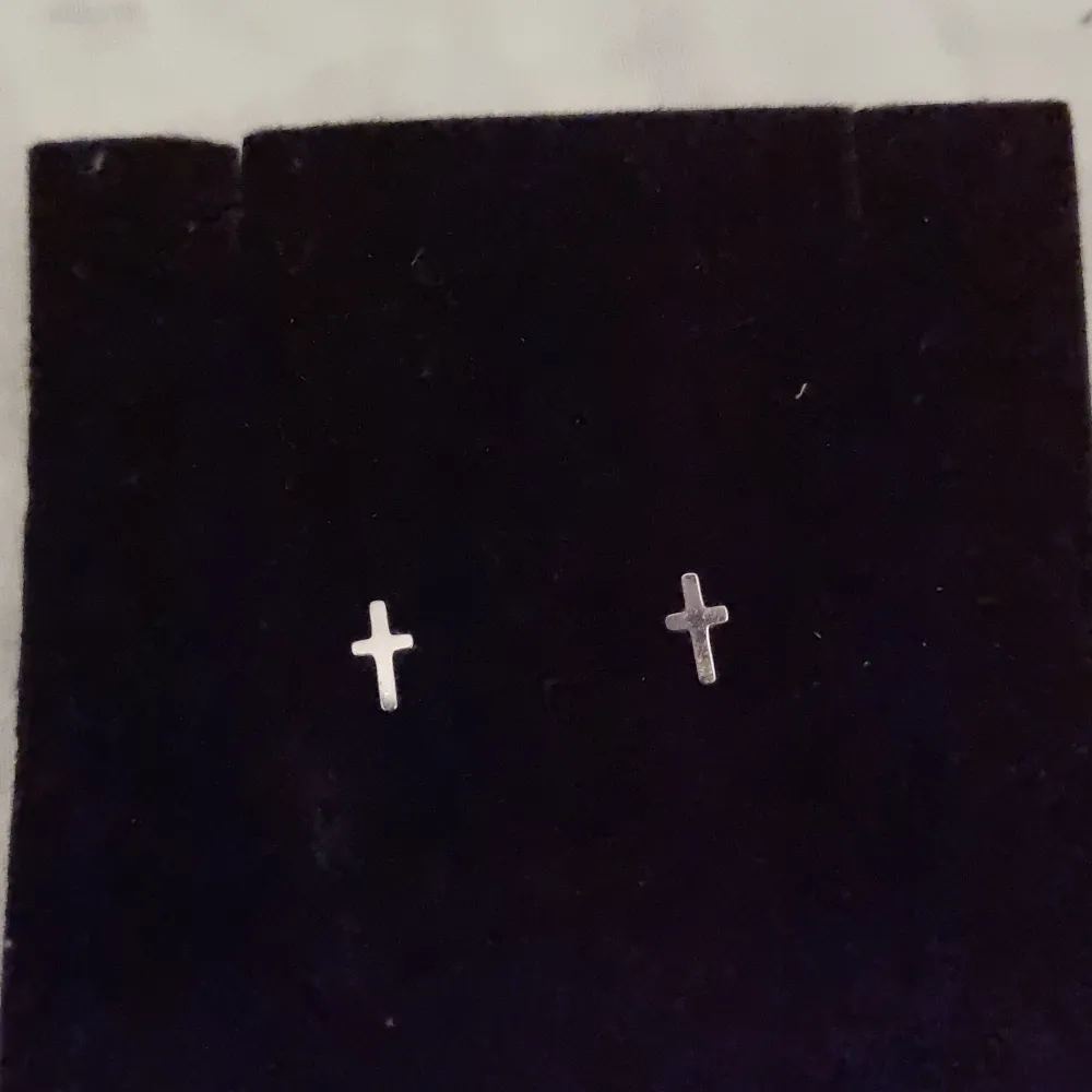 Ett par små korsformade silvriga örhängen från Edblad. I väldigt bra skick och medkommer två nya gummipluppar eller dem i metall om så önskas.. Accessoarer.
