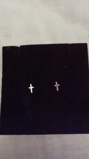 Edblad korsörhängen - Ett par små korsformade silvriga örhängen från Edblad. I väldigt bra skick och medkommer två nya gummipluppar eller dem i metall om så önskas.