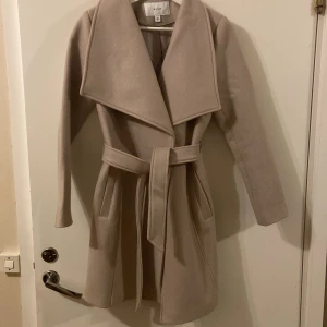Kappa - Kort beige kappa i storlek 34  Säljer pga ej använt efter inköp Nypris 999kr