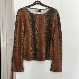 Ormmönster tröja  - Ormmönster tröja i bra skick, tror den är i satin. Köpt på Beyonce Retro och knappt använd. 