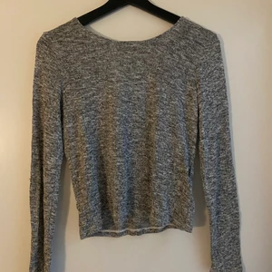 Ljus grå tröja  - Jätte fin öppning i ryggen. Ljusgrå i färgen och är stolek M men är aningen liten i stolek, så är nog mer stolek S. Köparen står för frakten 