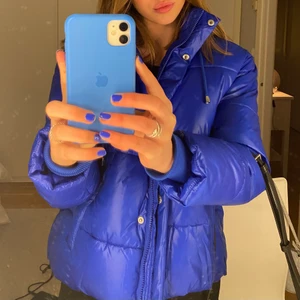 Blå Pufferjacket - superfin klarblå-glansig pufferjacka köpt i november 2020 för ca 900kr, sparsamt använd så i nyskick. säljs ej längre, är i strl xs men passar även s och ev m. frakt ingår ej, skriv för mer detaljer.