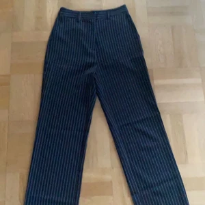 Randiga kostymbyxor - Säljer mina super snygga kostymbyxor från NAKD x DONNA ROMINA som tyvärr blivit för korta för mig. Byxorna när i nyskick och dem är super sköna med straightfit. Nypris 400kr säljer den för 200kr. Kontakta vid intresse, om flera är intresserade får ni buda om högsta pris och köparen står för frakten som räknas med i priset❤️ Skriv om ni har frågor!!
