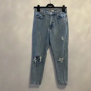 Ett par mom jeans med hål som inte kommer till användning längre, i bra skick och färgen har inte gått bort (köpare står för frakt & inga återbetalningar)
