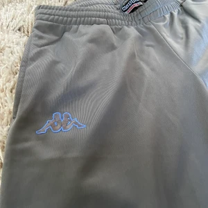 Kappa track pants vintage - Köpta second hand. Gråa, raka i modellen låg midja. Uppskattningsvis strlk 25/32. I mycket fint skick utan slitningar.