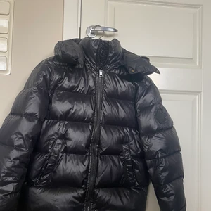 Svart pufferjacka - Säljer en supersnygg pufferjacka från Diesel. Använd bara några gånger och den är i nyskick. Den är lite glansig och har en vit ”text” på ryggen. Skriv vid intresse eller om ni har några frågor eller för fler bilder. Nypris: 2500kr (Luvan är också avtagbar)