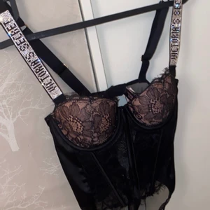 Victoria secret body - En fin svart/begie spets body med glittriga axelband. Den är helt oanvänd, plomberad och prislapp kvar. Kvittot finns även om man vill. Säljer då den är för liten för mig i bysten.