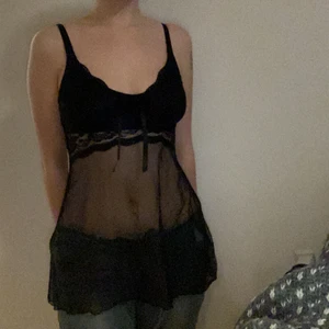 Svart meshlinne med spetsdetaljer - Svart meshlinne med spetsdetaljer, den är också genomskinlig över bysten som man kan se på tredje bilden. 