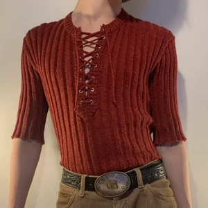 Vintage vinröd snörning stickad tröja - Vinröd vintage stickad tröja med trekvarts ärmar och snörning vid bröstet 🧣 Denna tröjan är perfekt för layering då den är varm men inte överdrivet tjock! Färger sticker ut men går också att matchas med alla neutrala färger som helst, militärgrön, beige eller mörkgrå! Manchesterbyxor och ett par kängor gör outfiten ännu mysigare och helt ultimat för en tidig 2000-tals höst outfit!